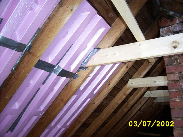 I'm stuffing the seams of the crossbeams with insulation material and holding it in place with duct tape as well.
