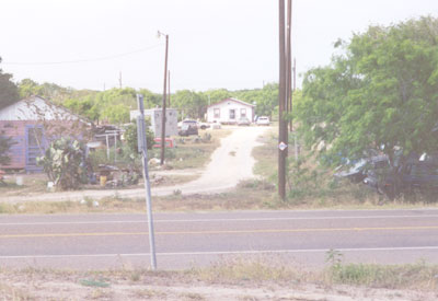 Taken from the bank of the Hannis Turberville Reservoir  that runs along FM-1925, on the south side, this shows a road, really a multiple-user driveway, leading north into Colonia Bernal.
