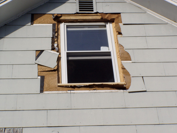 A close up of the window from the outside. As you can see, the framing is in place. Next we'll replace the broken siding and add decorative framing to the outside. The window isn't secured yet, as the framing is not firmly nailed into place yet.