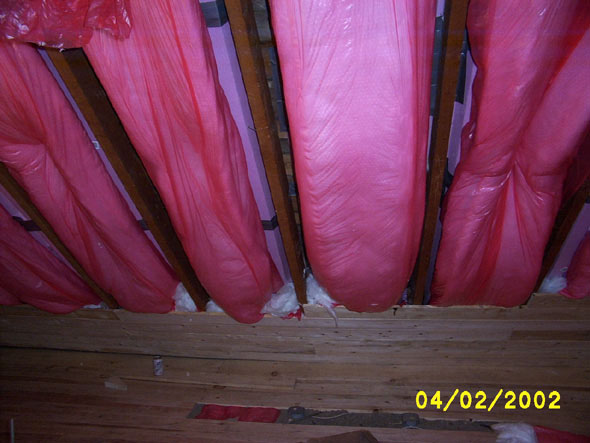 I've been packing the space between the roll insulation with loose insulation material.