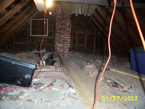 With most of the junk moved to the south side of the attic, I began by working north.  The chimney in the background is not an active one.  While it is taking up space from the cellar crawlspace to the attic, it ends a few inches short of the roof.  My best guess is that, while the house was divided into apartments, there once was two separate heating systems.