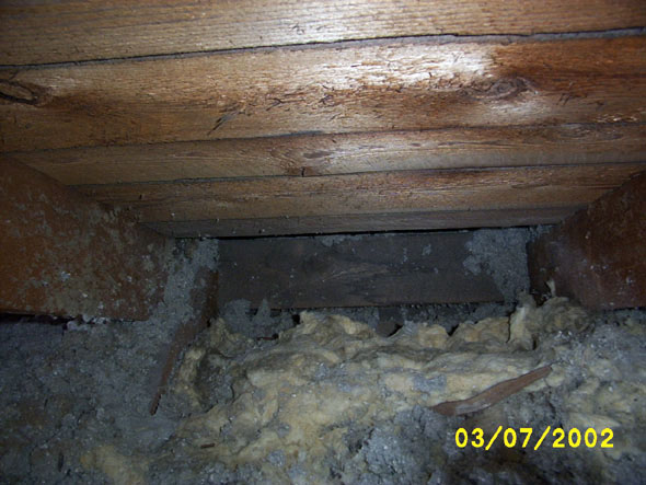 This is where I could see the results of ice damming.  A week ago, the inner part of the roof was damp and the insulation was wet.  It's right about in the center of the attic on the east side, at the site of our worst ice dam of the winter.  Fortunately, the wood seems to be in good shape.  Unfortunately, it is one of the eaves that is blocked.