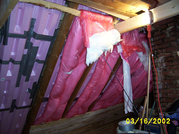 Above the level of the ceiling, I've hung some scrap boards to secure the rolls of insulation.