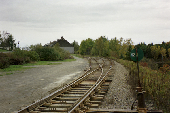 The railroad tracks south of Soldier Pond Road, with a couple of warehouses in the background.